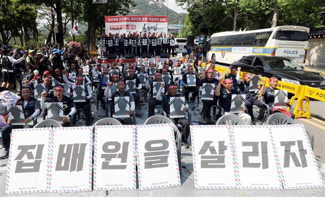 6일 오후 청와대 사랑채 앞에서 열린 우정노동자 총파업 결의대회에서 삭발식을 마친 전국집배노동조합원들이 토요택배 폐지와 정규인력 증원 등을 촉구하며 구호를 외치고 있다.2019.7.6 뉴스1