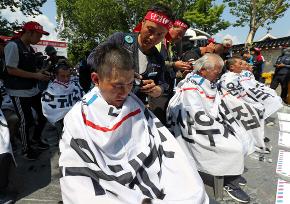 6일 서울 종로구 청와대 사랑채 인근에서 민주노총 공공운수노조 전국집배노동조합원들이 정규직 증원 및 토요 근무 폐지 등을 촉구하며 삭발식을 하고 있다. 2019.7.6  연합뉴스