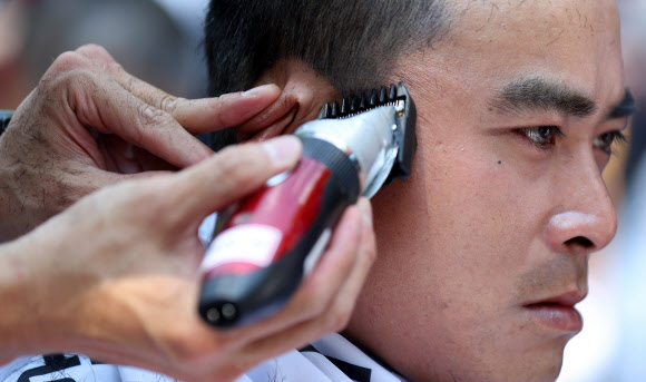 6일 서울 종로구 청와대 사랑채 인근에서 ‘토요택배 완전 폐지 및 정규인력 증원’ 등을 촉구하며 열린 우정노동자 총파업 결의대회에서 조합원이 삭발식을 하고 있다. 2019.7.6  연합뉴스