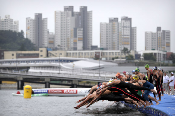 13일(현지시간) 한국 여수에서 열린 세계 수영선수권 대회 ‘오픈워터수영 남자 5km’ 경기에서 선수들이 힘찬 출발을 하고 있다. AP 연합뉴스