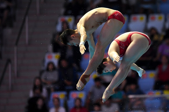 중국의 리안준지와 시야지가 13일(현지시간) 광주에서 열린  ‘2019 광주세계수영선수권대회’ 혼성 싱크로나이즈드 10m 플랫폼 다이빙 결승전에서 멋진 연기를 선보이고 있다. AFP 연합뉴스