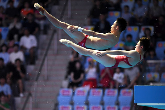 중국의 리안준지와 시야지가 13일(현지시간) 광주에서 열린  ‘2019 광주세계수영선수권대회’ 혼성 싱크로나이즈드 10m 플랫폼 다이빙 결승전에서 멋진 연기를 선보이고 있다. AFP 연합뉴스