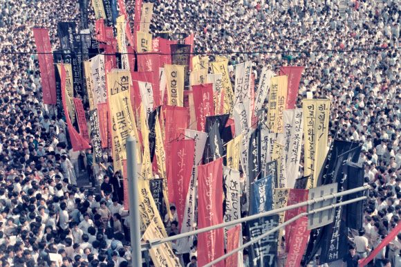 1987년 6월 군사정권에 항거하는 시위 도중 경찰이 쏜 최루탄에 맞아 쓰러진 연세대생 고(故) 이한열 열사의 장례식 전후 상황이 당시 서울에서 근무하던 외신기자의 카메라에 담겼다가 국내에 처음 공개됐다. 14일 이한열기념사업회에 따르면 언론인 출신 주리시(朱立熙) 대만정치대 한국어과 교수는 이 열사가 숨진 1987년 7월 5일부터 장례식이 열린 9일까지 시위 등을 촬영한 사진 등 약 300장을 CD에 담아 지난 5일 기념사업회에 보냈다. 사진은 연대 철길 아래를 지나는 만장들. 2019.7.14  주리시 교수 촬영·이한열기념사업회 제공