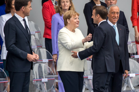 최근 건강이상설이 나돌고 있는 앙겔라 메르켈(가운데) 독일 총리가 14일(현지시간) 프랑스 파리에서 열린 프랑스대혁명 기념식에 참석해 에마뉘엘 마크롱 프랑스 대통령과 반갑게 인사를 나누고 있다. 파리 EPA 연합뉴스