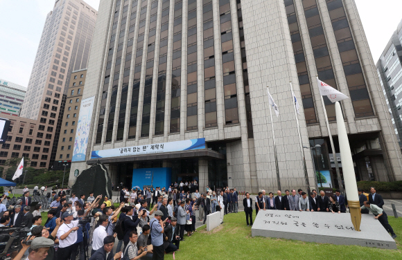 16일 오전 서울 중구 한국프레스센터 앞마당에서 열린 ‘굽히지 않는 펜’ 제막식 참석자들이 기념촬영을 하고 있다. 전국언론노동조합, 한국기자협회, 한국PD연합회가 언론시민사회단체에 언론자유 조형물 건립을 제안해 만들어진 ‘굽히지 않는 펜’은 언론 민주화를 위해 평생을 바친 청암 송건호 선생의 지론인 ‘역사 앞에 거짓된 글을 쓸 수 없다’는 문구를 새긴 돌판에 만년필 모양의 조형물이 자리잡고 있다. 2019. 07.16. 박지환 기자 popocar@seoul.co.kr