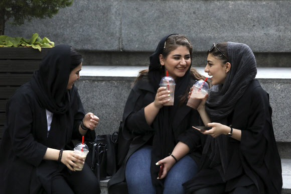 이란의 수도 테에란 북부의 한 쇼핑몰 외부 계단에 앉은 여성들이 지난 2일 커피를 마시며 이야기를 나누고 있다. 이들이 머리를 가리는 히잡을 둘렀지만 머리가 절반 이상 보인다. AP연합뉴스