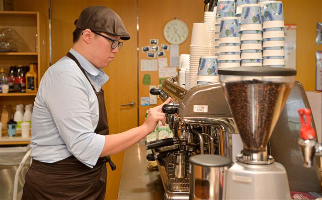 지난 17일 경기 성남시 분당구 정자동 SK㈜ C&C사옥 카페포유로 첫 출근한 유석훈씨가 커피를 만들고 있다. SK㈜ 제공