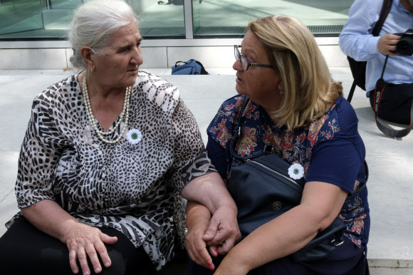 ‘스레브레니차의 어머니들’ 회원인 무니라 수바시치(왼쪽)와 네르미나 라코타가 19일(현지시간) 헤이그의 네덜란드 대법원 재판을 방청한 뒤 계단에 앉아 서로를 위로하고 있다. 헤이그 AP 연합뉴스