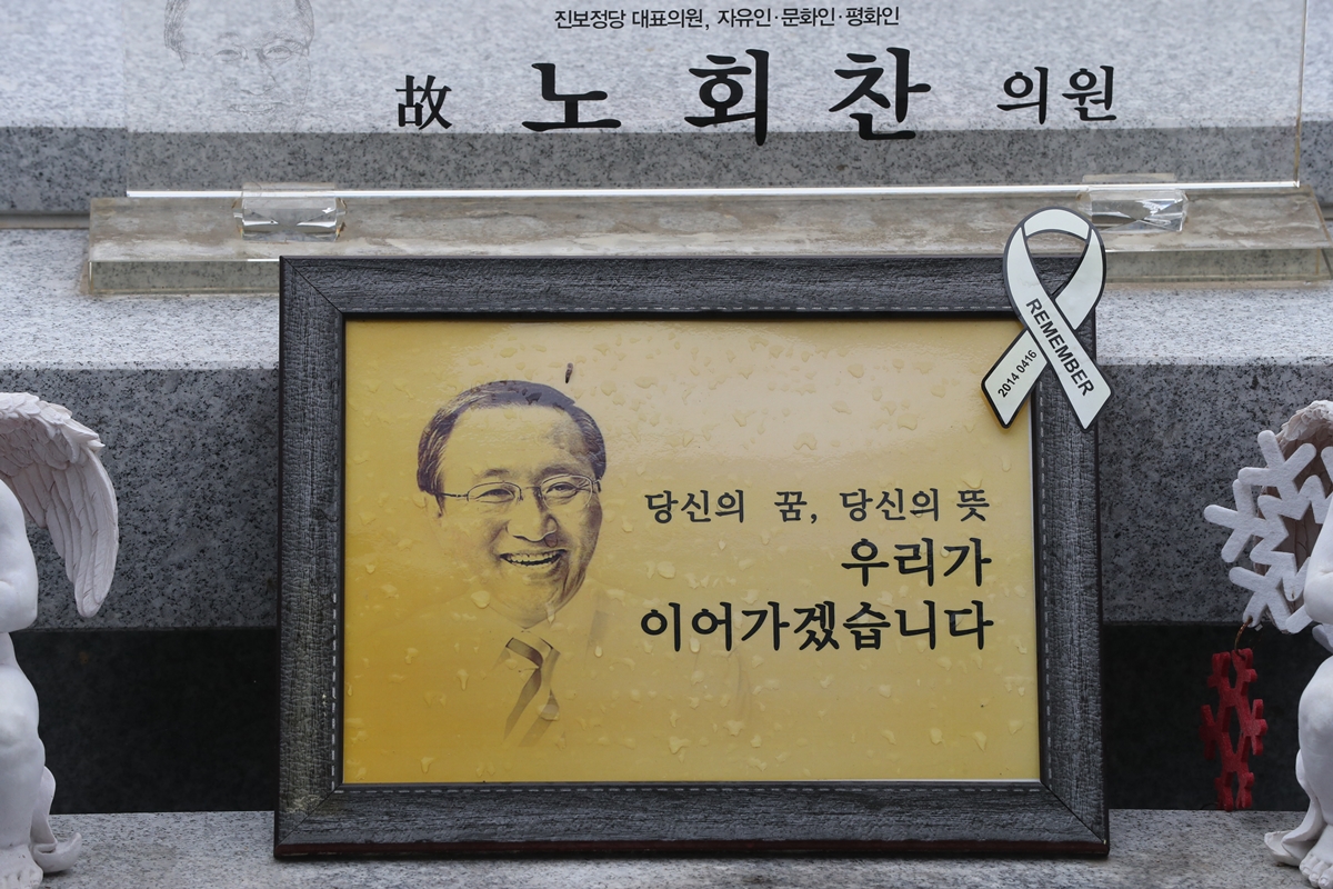 20일 경기 남양주시 모란공원에서 열린 고 노회찬 전 정의당 의원 서거 1주기 추모제에서 고인의 사진이 묘역에 놓여 있다. 2019.7.20 연합뉴스