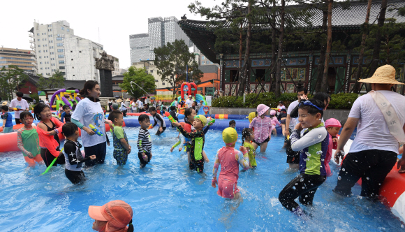 21일 서울 종로구 조계사 대웅전 뒷마당에 마련된 야외풀장에서 어린이들이 신나는 물놀이를 즐기고 있다. 조계사는 이날 불교학교 어린이들을 위한 여름나기 프로그램의 일환으로 7개의 풀장과 물놀이기구 4개를 설치해 6~13세 어린이 300여 명에게 개방했다.2019. 7. 21. 박윤슬 기자 seul@seoul.co.kr
