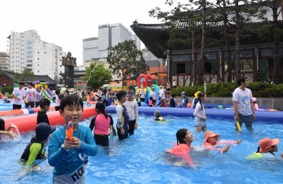 21일 서울 종로구 조계사 대웅전 뒷마당에 마련된 야외풀장에서 어린이들이 신나는 물놀이를 즐기고 있다. 조계사는 이날 불교학교 어린이들을 위한 여름나기 프로그램의 일환으로 7개의 풀장과 물놀이기구 4개를 설치해 6~13세 어린이 300여 명에게 개방했다.2019. 7. 21. 박윤슬 기자 seul@seoul.co.kr