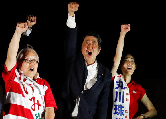 아베 신조 일본 총리(오른쪽 두 번째)가 참의원 선거 하루 전인 지난 20일 밤 도쿄 아키하바라에서 지지를 호소하고 있다. 로이터=연합뉴스