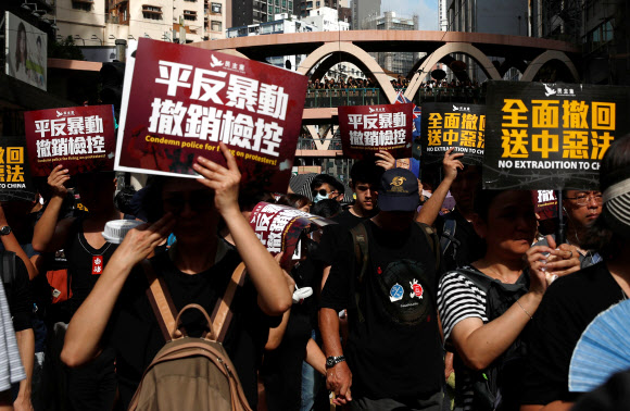 ‘범죄인 인도법안’(송환법) 반대 시위가 열린 21일 홍콩 코즈웨이베이의 빅토리아공원에서 홍콩 시민들이 ‘송환법 전면 철회’ 등의 피켓을 들고 행진하고 있다. 홍콩 로이터 연합뉴스