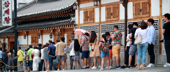 절기상 중복인 22일 오후 서울 종로구의 한 삼계탕 전문점 앞에 시민들과 외국인 관광객들이 점심 식사를 위해 줄지어 서 있다. 2019.7.22  연합뉴스