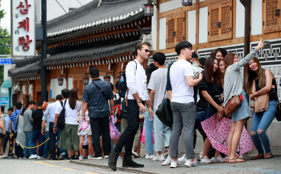 절기상 중복인 22일 오후 서울 종로구의 한 삼계탕 전문점 앞에서 외국인 관광객들이 점심 식사를 위해 차례를 기다리던 중 기념사진을 찍고 있다. 2019.7.22  연합뉴스
