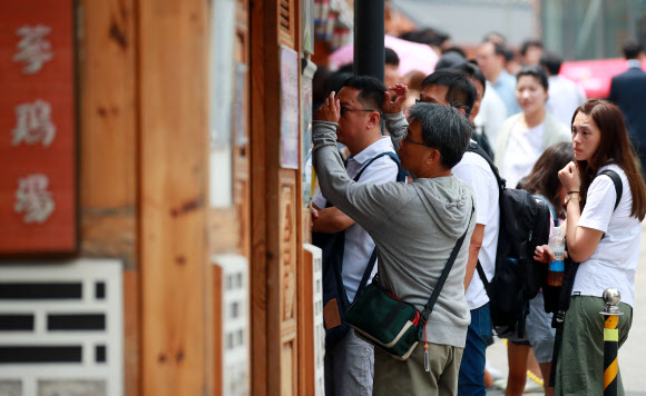 절기상 중복인 22일 오후 서울 종로구의 한 삼계탕 전문점 앞에서 시민들과 외국인 관광객들이 점심 식사를 위해 식당에 들어가기 위해 차례를 기다리고 있다. 2019.7.22  연합뉴스