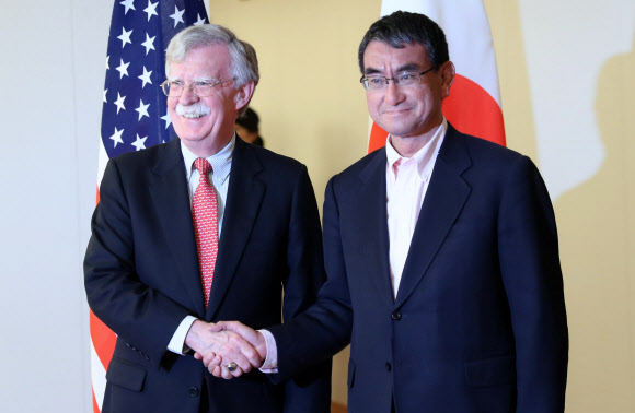 존 볼턴(왼쪽) 미국 백악관 국가안보보좌관이 22일 도쿄에서 고노 다로 일본 외무상과 만나 손을 맞잡고 있다. 도쿄 AFP 연합뉴스 