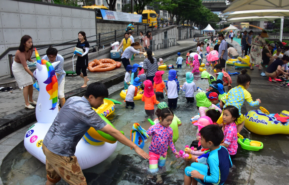 대서인 23일 서울 송파구 성내천을 찾은 어린이들이 물놀이를 즐기고 있다. 송파구는 성내천 물놀이장에 도서를 비치하고 파라솔과 테이블 등 독서 공간을 제공하는 ‘여름행복문고’를 일주일간 운영한다고 밝혔다.  2019.7.23.   이종원 선임기자 jongwon@seoul.co.kr