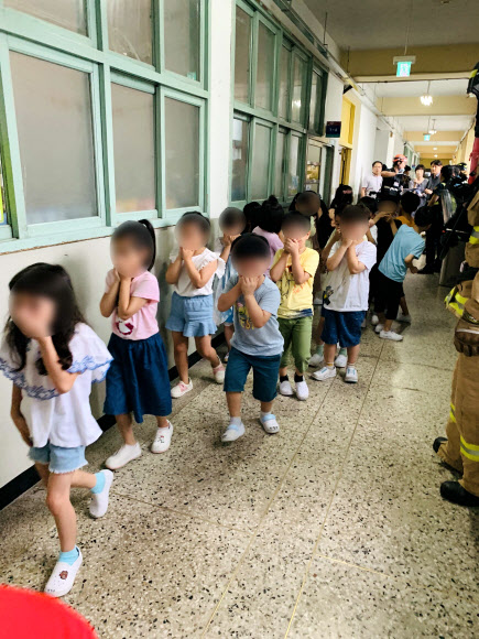 초등학교서 포르말린 용액 유출… 인명피해 없이 1200명 대피  25일 오전 서울 구로구의 한 초등학교에서 인체 흡입 시 유해한 화학 용액인 포르말린이 소량 유출되는 사고가 발생하자 이 학교 학생들이 손으로 코를 막은 채 줄지어 대피하고 있다. 구로소방서에 따르면 학교 관계자가 과학실에서 생물 표본 보존 용도로 쓰이는 포르말린이 든 1.5ℓ 유리병을 옮기다 실수로 떨어뜨려 용액 300㎖가 유출됐다. 교내에 있던 학생과 교사 1200명은 즉시 운동장으로 대피해 인명피해는 발생하지 않았다. 사고 직후 학생들은 모두 귀가 조치됐다.<br>구로소방서 제공