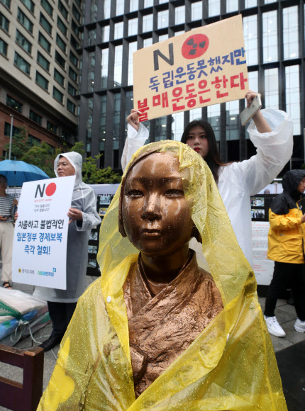 경기 의정부시의 부용고, 송현고, 의정부고 등 6개 고등학교 학생들이 26일 서울 종로구 옛 일본대사관 앞에서 ‘일본산 제품 불매운동 동참 선언 기자회견’을 했다. 한 참가 학생이 소녀상 뒤로 손팻말을 들고 있다. 2019.7.26  연합뉴스