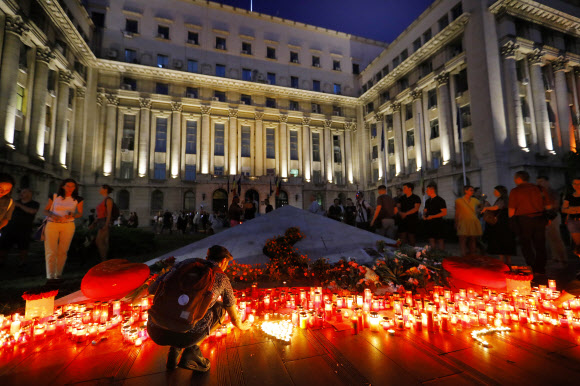 납치된 지 이틀 만에 용의자에게 살해된 것으로 보이는 15세 소녀 알렉산드라의 사진이 놓인 루마니아 내무부 청사 앞 계단에서 27일(현지시간) 시민들이 촛불을 바치며 애도하고 있다. 부큐레슈티 EPA 연합뉴스