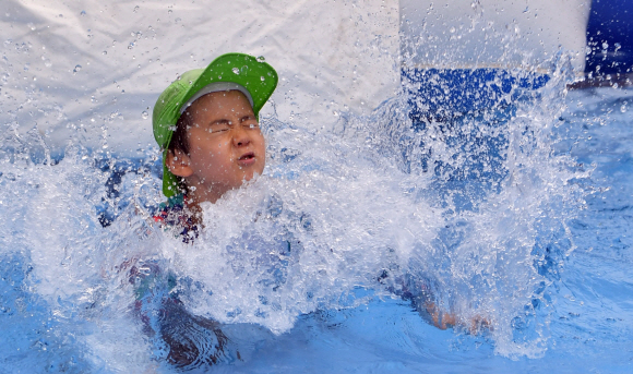 28일 서울 숭덕초등학교 에서 열린 성북문화바캉스에서 어린이들이 학교 운동장에 마련된 수영장에서 즐거운 표정으로 물놀이를 즐기고 있다. 2019.7.28 박지환기자 popocar@seoul.co.kr