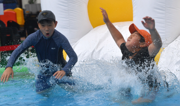 28일 서울 숭덕초등학교 에서 열린 성북문화바캉스에서 어린이들이 학교 운동장에 마련된 수영장에서 즐거운 표정으로 물놀이를 즐기고 있다. 2019.7.28 박지환기자 popocar@seoul.co.kr