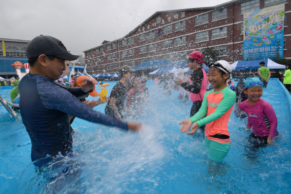 28일 서울 숭덕초등학교 에서 열린 성북문화바캉스에서 어린이들이 학교 운동장에 마련된 수영장에서 즐거운 표정으로 물놀이를 즐기고 있다. 2019.7.28 박지환기자 popocar@seoul.co.kr