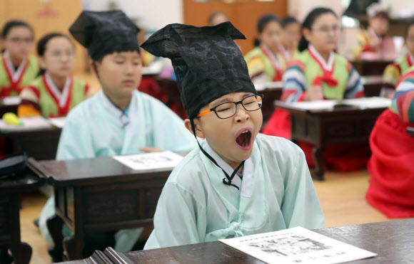 29일 부산 동래구 충렬사 안락서원 교육회관에서 열린 전통서당 체험 교실에서 학생들이 사자소학을 배우며 밀려오는 졸음에 하품하고 있다. 2019.7.29  연합뉴스