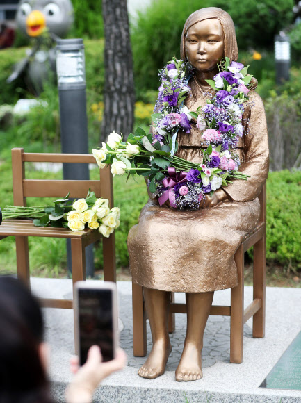29일 오전 경기도 오산시청 평화의 소녀상에서 세계일본군위안부 기림일을 앞두고 열린 ‘2019 오산평화의소녀상 헌화행사’에서 한 시민이 헌화를 마치고 소녀상 사진을 찍고 있다. 2019.7.29  연합뉴스