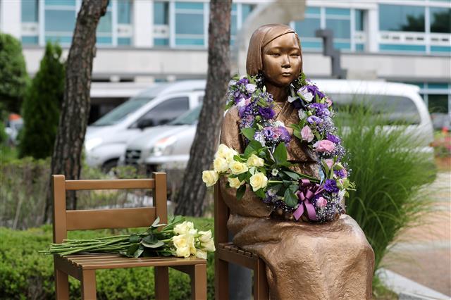 29일 오전 경기도 오산시청에서 열린 ‘2019 오산평화의 소녀상 헌화 행사’에서 소녀상에 시민들이 헌화한 꽃이 놓여 있다. 이번 행사에서는 세계 일본군 위안부 기림일(8월 14일)을 앞두고 일본의 위안부 피해자들에 대한 사과와 경제 보복 규탄의 목소리를 담은 성명서 발표를 함께했다. 2019.7.29 뉴스1