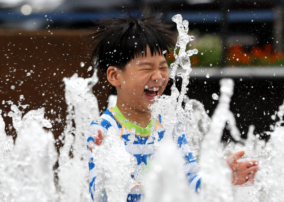 장마가 끝나고 본격적인 찜통더위가 시작된 29일 서울 종로구 광화문광장 분수대에서 한 어린이가 물놀이를 즐기고 있다. 기상청은 이날 전국의 낮 기온이 29∼34도의 분포로 평년(28∼32도)보다 높겠다고 밝혔다. 2019.7.29  연합뉴스