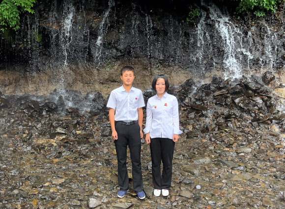 북한 학생들이 지난 24일 백두산 폭포에서 사진을 찍기 위해 포즈를 취하고 있다. TASS=연합뉴스 