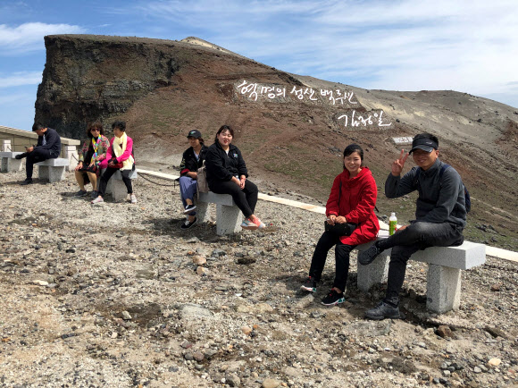 지난 24일 백두산 정상을 등반한 북한 관광객들. TASS=연합뉴스