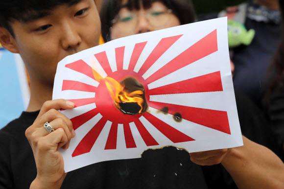 한국대학생진보연합 학생들이 29일 오후 서울 중구 미쓰비시 상사 앞에서 열린 일본의 강제징용 사죄 촉구 및 전범 기업 규탄 기자회견을 마친 뒤 욱일기를 불태우는 퍼포먼스를 하고 있다. 2019.7.29  연합뉴스