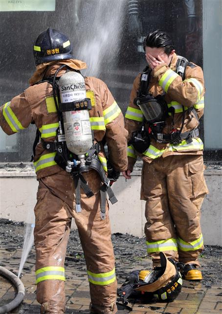 전국 대부분 지역예 폭염특보가 발효된 29일 오후 전북 전주시 송천동 상가건물에서 불이나 출동한 소방관이 화재 진압 중 얼굴에 흐르는 땀을 닦고 있다.2019.7.29 뉴스1