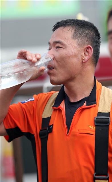 전국 대부분 지역예 폭염특보가 발효된 29일 오후 전북 전주시 송천동 상가건물에서 불이나 출동한 소방관이 화재 진압을 마친 뒤 물을 마시며 더위를 식히고 있다.2019.7.29 뉴스1