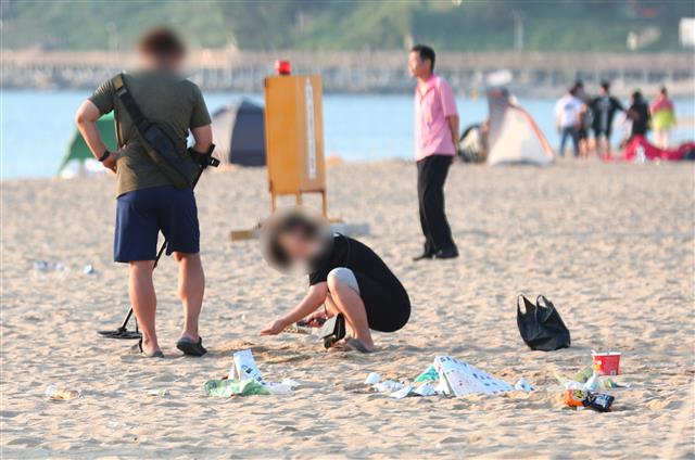 3일 오전 강원도 속초해수욕장에서 시민이 금속탐지기를 이용해 쓰레기가 널브러진 백사장을 훑고 있다. 2019.8.3 뉴스1