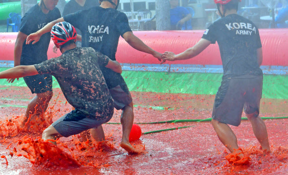강원 화천군 사내면 문화마을에서 ‘토마토축제’가 한창인 가운데 주말을 맞은 3일 군장병이 토마토축구를 즐기고 있다.  2019.8.3   화천군 제공