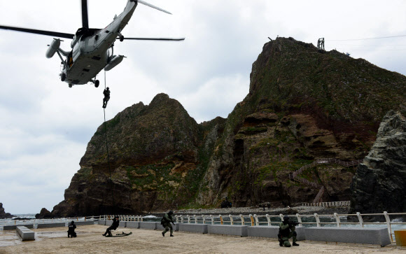 2013년 실시한 독도방어 훈련에서 해군 특전대대(UDT/SEAL) 및 해경 특공대 대원들이 해군 UH-60 헬기에서 강하하고 있다. 2013.10.25  해군 제공