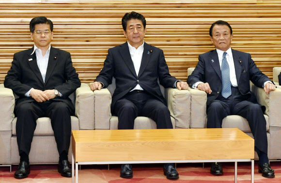 아베 신조(가운데) 일본 총리가 화이트리스트에서 한국을 배제하는 결정을 내린 각의(국무회의)에 참석해 굳은 표정으로 앉아 있는 모습. 도쿄 AP 연합뉴스