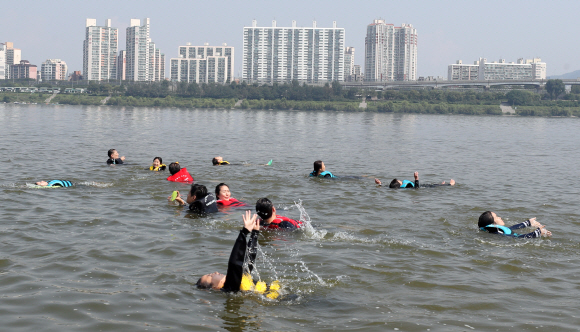 5일 오전 서울 송파구 안심생존수영교육지원센터 한강 실기교육장에서 참석자들이 생존수영을 배우고 있다. 서울시 교육청은 한강에서 생존수영을 배우고자하는 초등학교 3~6학년 학생과 부모님을 대상으로 이날부터 오는 9일까지 교육을 진행한다. 2019. 08.05. 박윤슬 기자 seul@seoul.co.kr