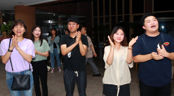 6일 새벽 서울 종로구 한국교회 100주년 기념관에서 명성교회 설립자 김삼환 목사의 아들 김하나 위임목사 청빙 결의 무효소송 재심 결과가 발표된 뒤 회의장 밖에서 장로회신학대 신학생 등 세습 반대 측 관계자들이 박수를 치며 재판국의 판결 결과를 환영하고 있다. 명성교회가 속한 대한예수교장로회(예장) 통합 총회 재판국은 이날 명성교회 담임목사직 세습이 교단 헙법상 세습금지 조항을 위반해 무효라 판결했다. 2019.8.6  연합뉴스