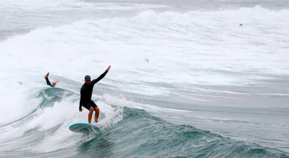 파도 즐기는 서퍼들