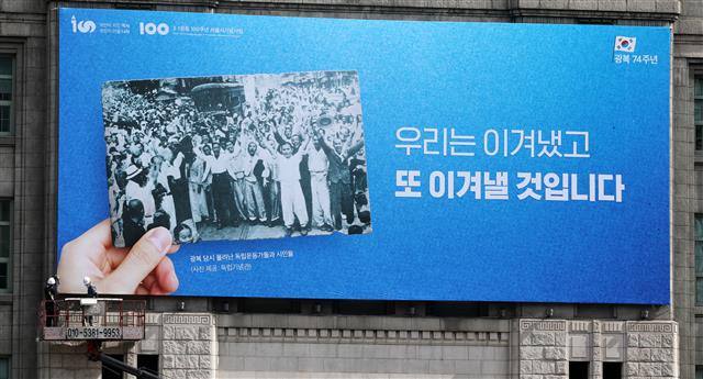 11일 서울 중구 서울도서관 외벽에서 관계자들이 서울광장 꿈새김판을 교체하고 있다. 서울시는 광복 제74주년을 맞아 ‘우리는 이겨냈고 또 이겨낼 것입니다’라는 문구로 꿈새김판을 교체했다. 서울시는 최근 불거지고 있는 한·일간 경제·외교적 분쟁 등 광복 이후에도 남아있는 갈등을 전 시민들과 지혜롭게 극복하자는 염원을 담아 이번 꿈새김판을 기획했다고 밝혔다. 2019.8.11 뉴스1