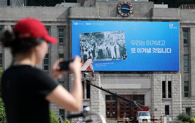 11일 서울 중구 서울도서관 외벽에서 관계자들이 서울광장 꿈새김판을 교체하고 있다. 서울시는 광복 제74주년을 맞아 ‘우리는 이겨냈고 또 이겨낼 것입니다’라는 문구로 꿈새김판을 교체했다. 서울시는 최근 불거지고 있는 한·일간 경제·외교적 분쟁 등 광복 이후에도 남아있는 갈등을 전 시민들과 지혜롭게 극복하자는 염원을 담아 이번 꿈새김판을 기획했다고 밝혔다. 2019.8.11 뉴스1