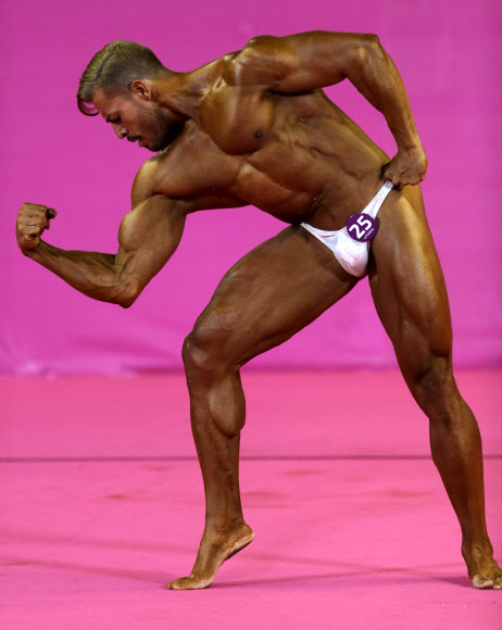 10일(현지시간) 페루 리마에서 열리고 있는 ‘팬 아메리칸 게임(Pan American Games)’중 첫 공식 종목으로 선보인 보디빌딩 경기에서 엘살바도르 선수가 멋진 근육을 뽐내고 있다. AP 연합뉴스