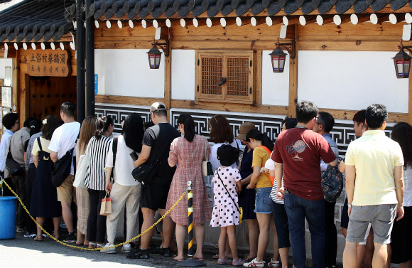 휴일이자 말복인 11일 오후 서울 종로구의 한 삼계탕 전문점을 찾은 시민들이 입장을 기다리고 있다. 2019.8.11  연합뉴스
