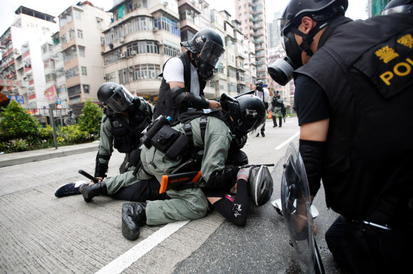 11일(현지시간) 홍콩 경찰이 경찰서 인근에서 반정부 시위대 참가자를 진압하고 있다. 2019.8.12  로이터 연합뉴스