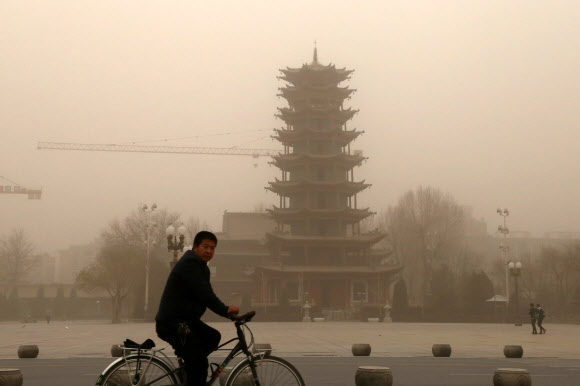 가뜩이나 대기오염이 극심한 중국에서 기후변화의 영향이 커지며 해마다 100만명 이상이 조기 사망하는 것으로 추산됐다. 사진은 2018년 11월25일 중국 간쑤성 장예에서 자전거를 탄 한 남성이 대기오염에 따른 초미세먼지로 한치의 앞도 분간하기 어려울 정도로 시계가 제로인 거리를 달리고 있다. 장예 AFP 연합뉴스